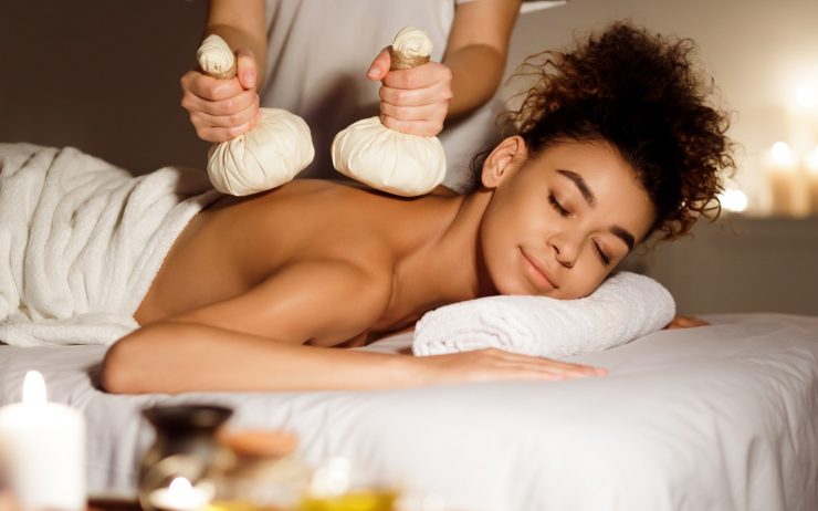 Oriental therapy. Lady receiving herbal massage at spa center